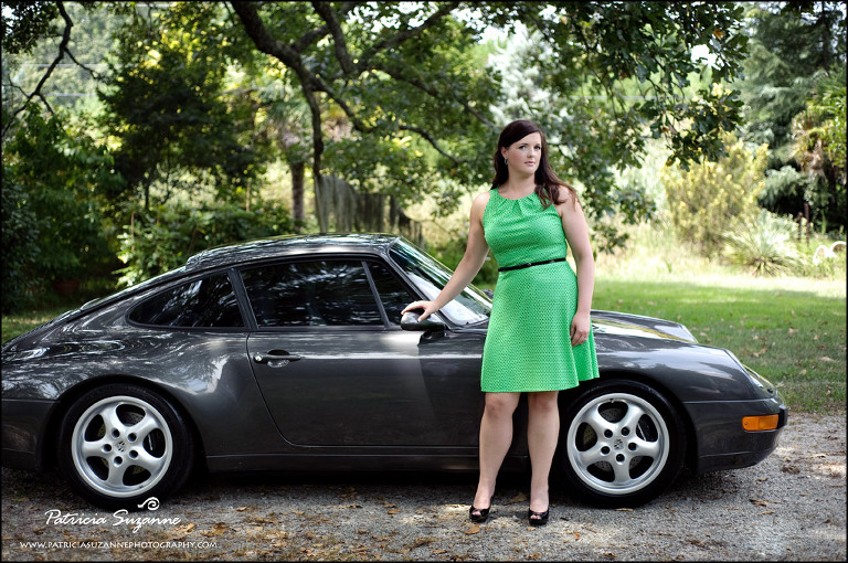 woman in green dress posing in front of porsche
