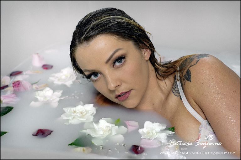 Milk bath boudoir photograph with gardenias floating on the water