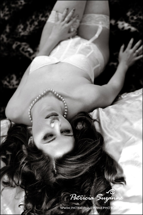 black and white boudoir photo of woman in white lace lingerie